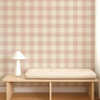 Scion Central Check Blush wallpaper styled behind a wooden bench, displaying large-scale pink and cream check pattern.