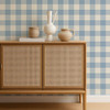 Scion Central Check Cornflower wallpaper used behind a rattan-front cabinet, highlighting fresh blue gingham design.