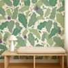 Scion Pomona Fig Fig Forest wallpaper styled behind a wooden bench, showcasing oversized green fig leaf design.