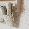 Little Dutch Blueberry Leaves White Green wallpaper behind vintage cabinet with baby sleeping bag.