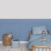 Little Dutch Forest Treasures White Blue wallpaper above blue wall panelling in a child’s bedroom with wooden bed.