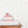 Little Dutch Fairy Blossom White Pink wallpaper behind wooden changing table with folded baby bedding.