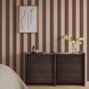 Made Demi Mocha Wide Stripe wallpaper in bedroom with dark wood furniture and warm tones.