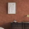 Made Shae Terracotta Limewash wallpaper in bedroom with dark wood furniture and minimalist decor.