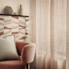 Romo Manzu wallpaper Tuscan pink geometric design in cosy living space with armchair and curtains