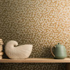 Galerie gold hexagon wallpaper feature wall with shelf and decor styling