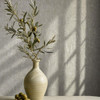 grey textured wallpaper feature wall with ceramic vase and natural light shadow pattern
