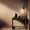 brown and gold floral wallpaper feature wall with wooden console table and warm lighting