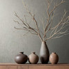 grey textured wallpaper feature wall with ceramic vases and branch styling on wooden surface