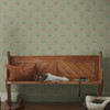 sage green floral wallpaper feature wall with wooden bench and warm interior styling