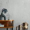 textured grey wallpaper in living space with furniture and metallic accessories