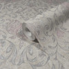 close up of wallpaper roll showing intricate damask design and subtle shimmer finish