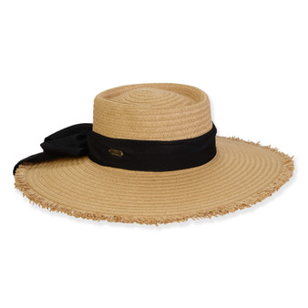 Front view of tan woven straw sun hat featuring flat crown, wide frayed brim, and black ribbon band tied in a side bow.