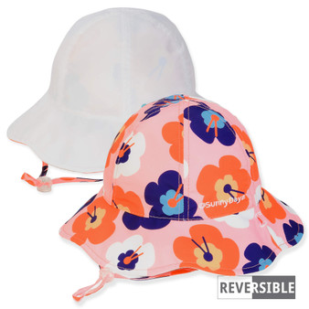 Three-quarter view of a reversible kids' bucket hat featuring a pink poppy floral print side and a solid white side.