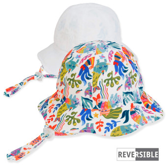 Three-quarter view of a reversible kids' bucket hat featuring a colorful mermaid aquatic print side and a solid white side.