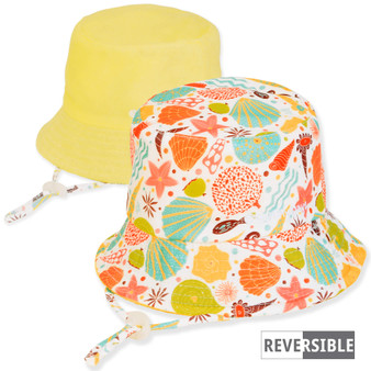 Three-quarter view of a reversible kids' bucket hat featuring a colorful seashell print side and a solid yellow side.