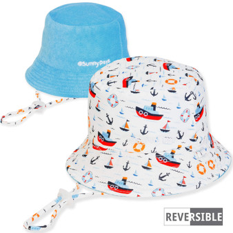 Three-quarter view of a reversible kids' bucket hat featuring a nautical boat and anchor print side and light blue side.