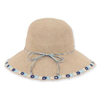 Three-quarter profile view of a tan crocheted bucket hat featuring a rounded crown, thin cord band, and blue floral-embroidered brim.