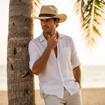 Lifestyle three-quarter view of the Sun N Sand HTT1304 men's straw western hat in Natural, featuring a dark brown braided faux-leather band and a ventilated cattleman crown for rugged beach elegance and breathable sun protection while relaxing by the