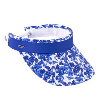 Three-quarter view of a royal blue performance visor featuring a white sea turtle print brim, white coiled elastic strap, and silver logo-plate.
