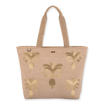 Front view of a rectangular beige woven jute tote featuring gold embroidered pineapple graphics, wide handles, and metal hardware.