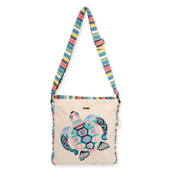 Front view of a rectangular beige crossbody bag with colorful embroidered sea turtle, striped strap, top trim, and metal hardware.