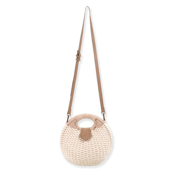 Front view of a circular woven straw bag featuring tan leather-wrapped handles, an adjustable crossbody strap, and antiqued gold-tone hardware