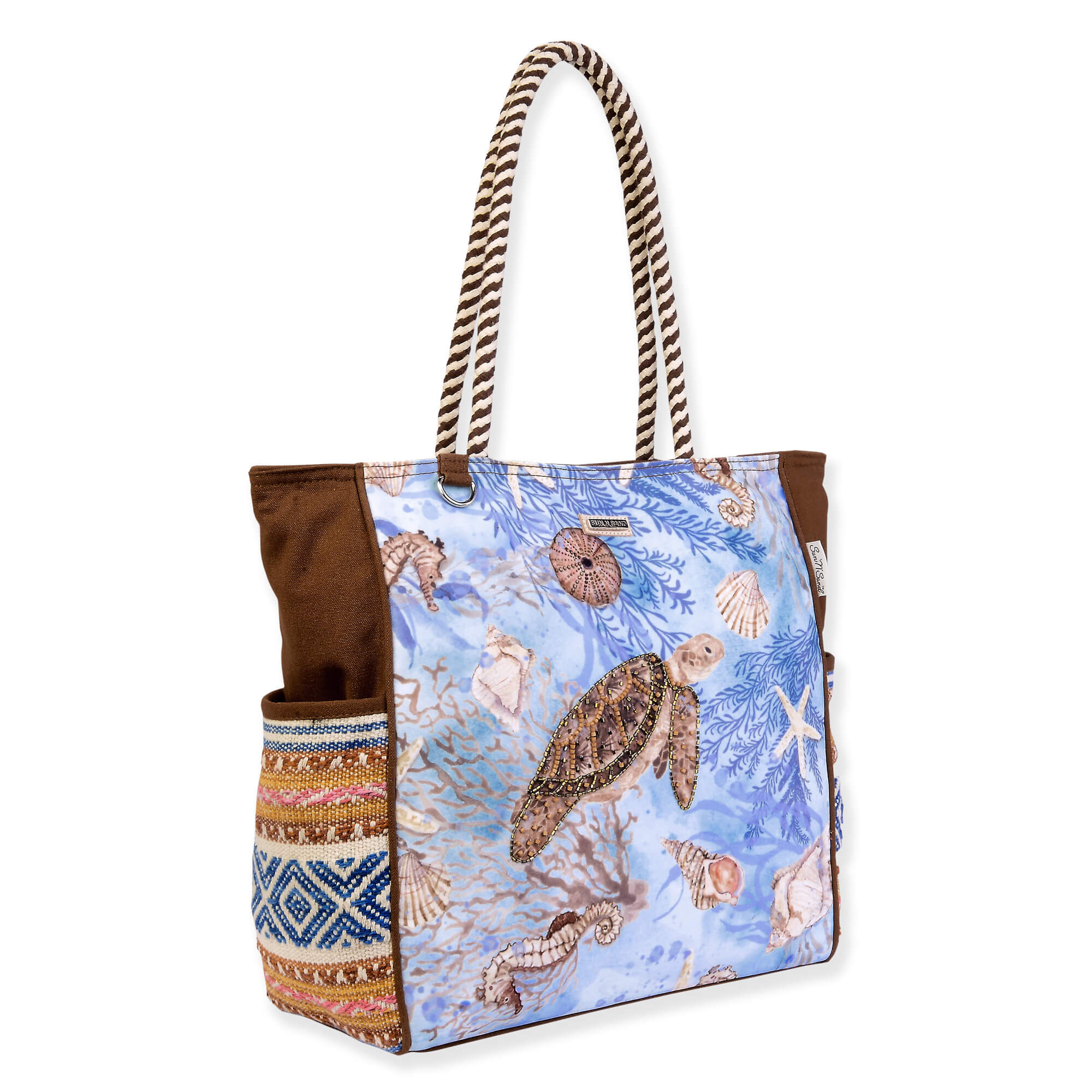 Canvas beach tote bag with vintage sea turtle and coral artwork, patterned side panel, brown fabric sides, rope handles, angled side view