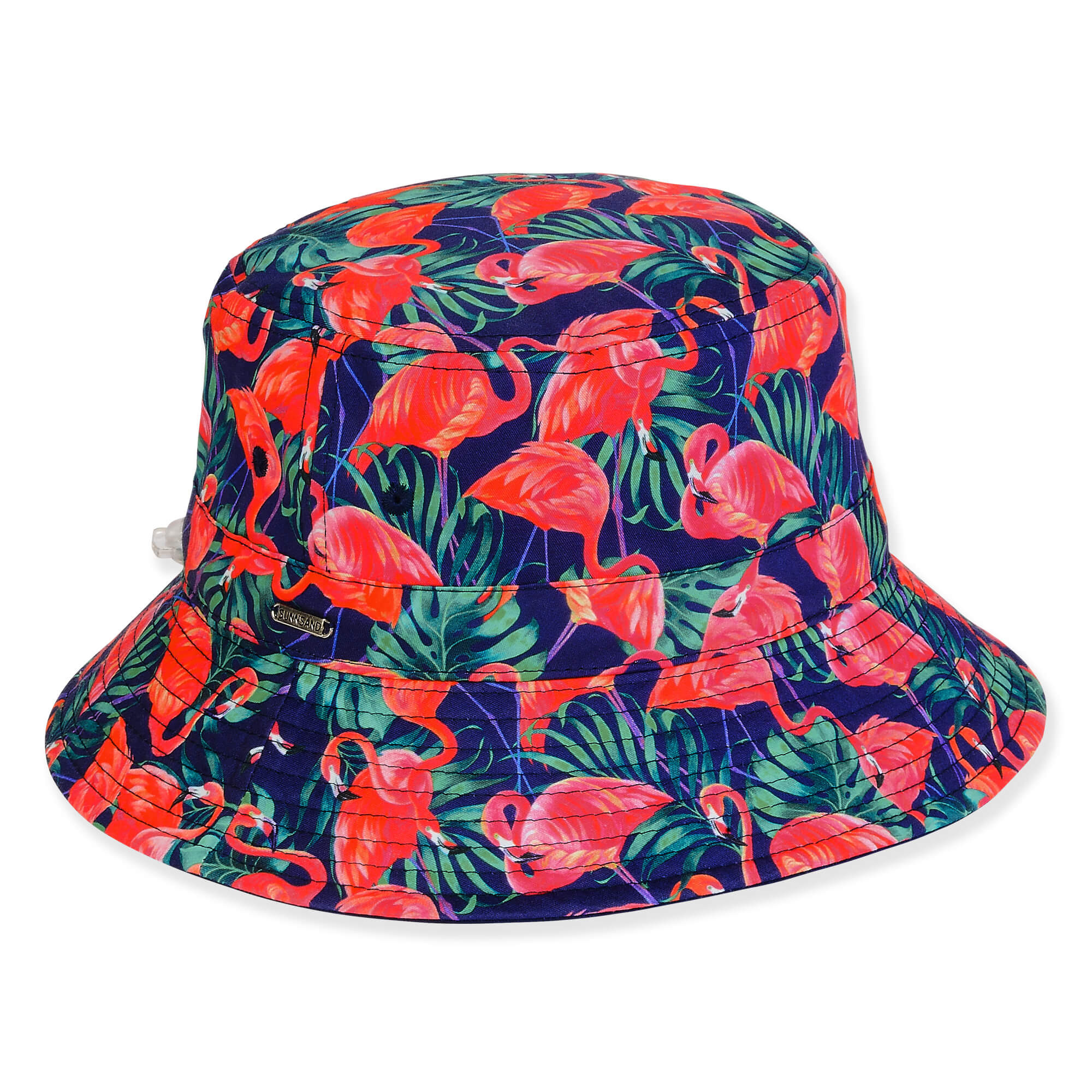Three-quarter view of a navy bucket hat featuring pink flamingo and green palm leaf prints, textured canvas, and gold hardware.