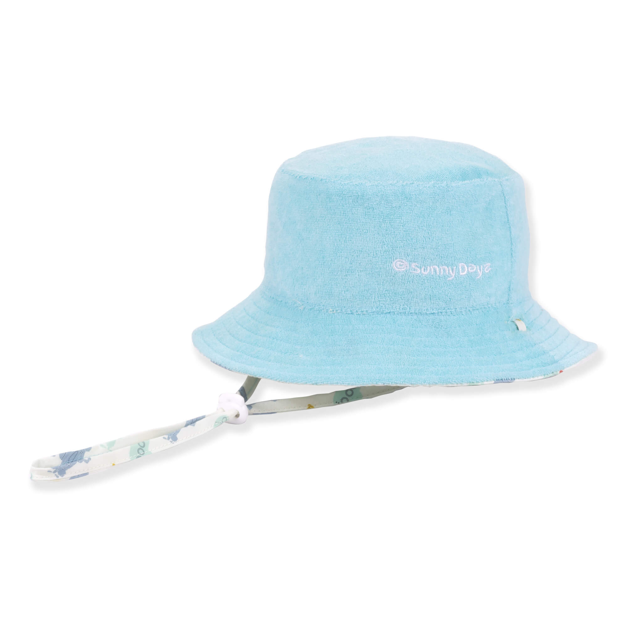 Three-quarter view of a light blue terry cloth bucket hat featuring white embroidered text and an adjustable patterned chin strap.
