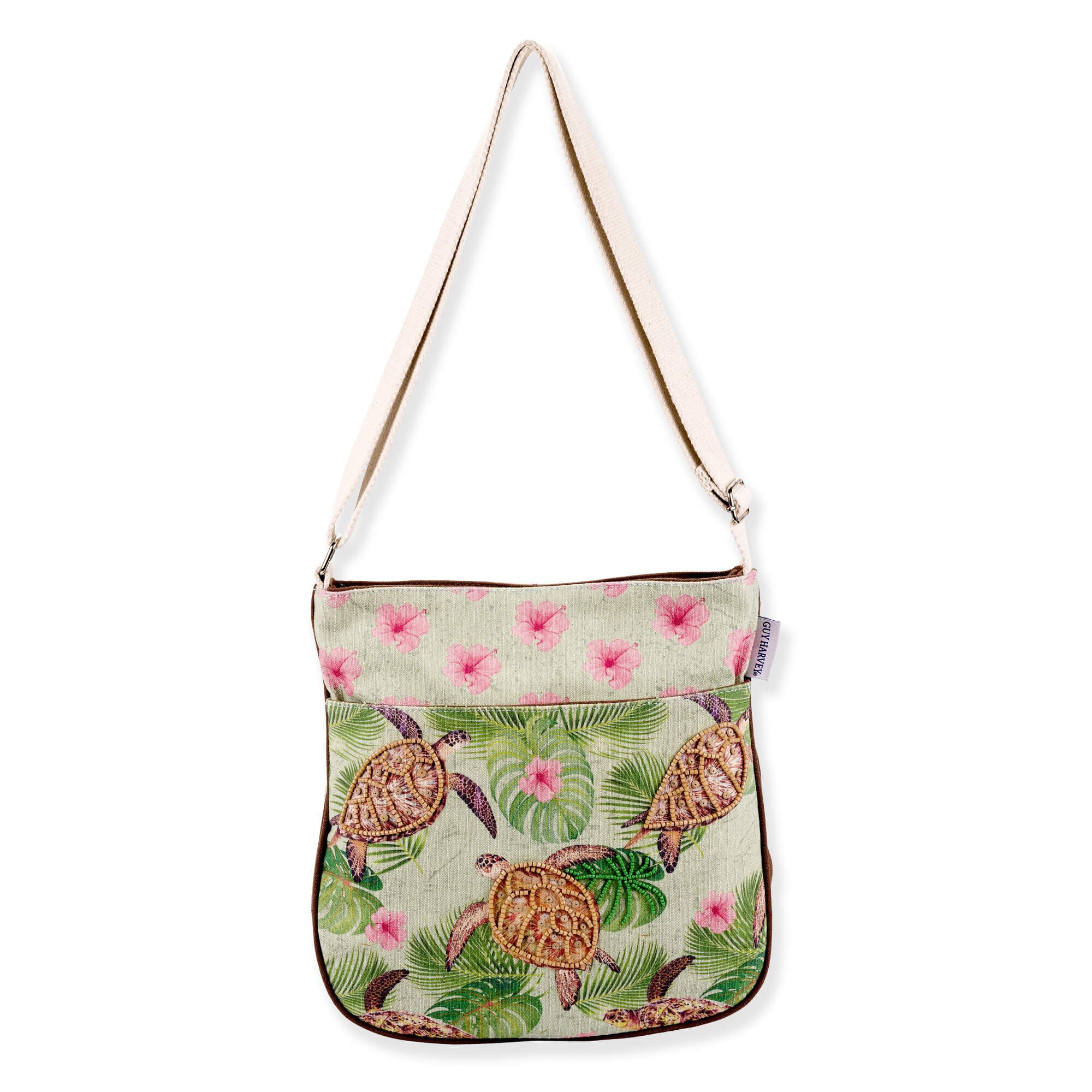 front view of a rectangular sage green crossbody featuring printed sea turtles, tropical leaves, pink flowers, and silver metal hardware.
