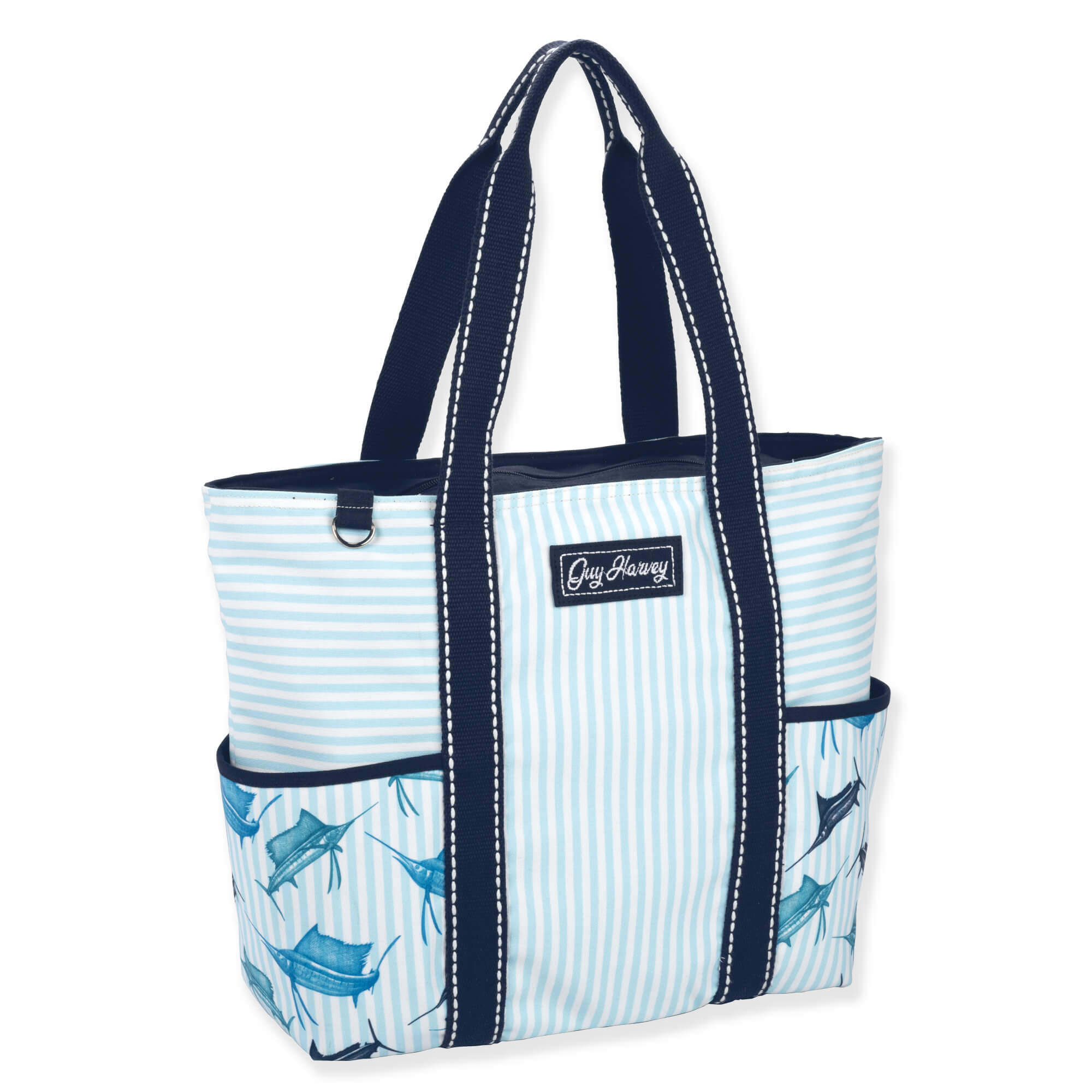 side view of a rectangular blue striped tote featuring marlin graphics, side pockets, navy canvas handles, and silver metal hardware.