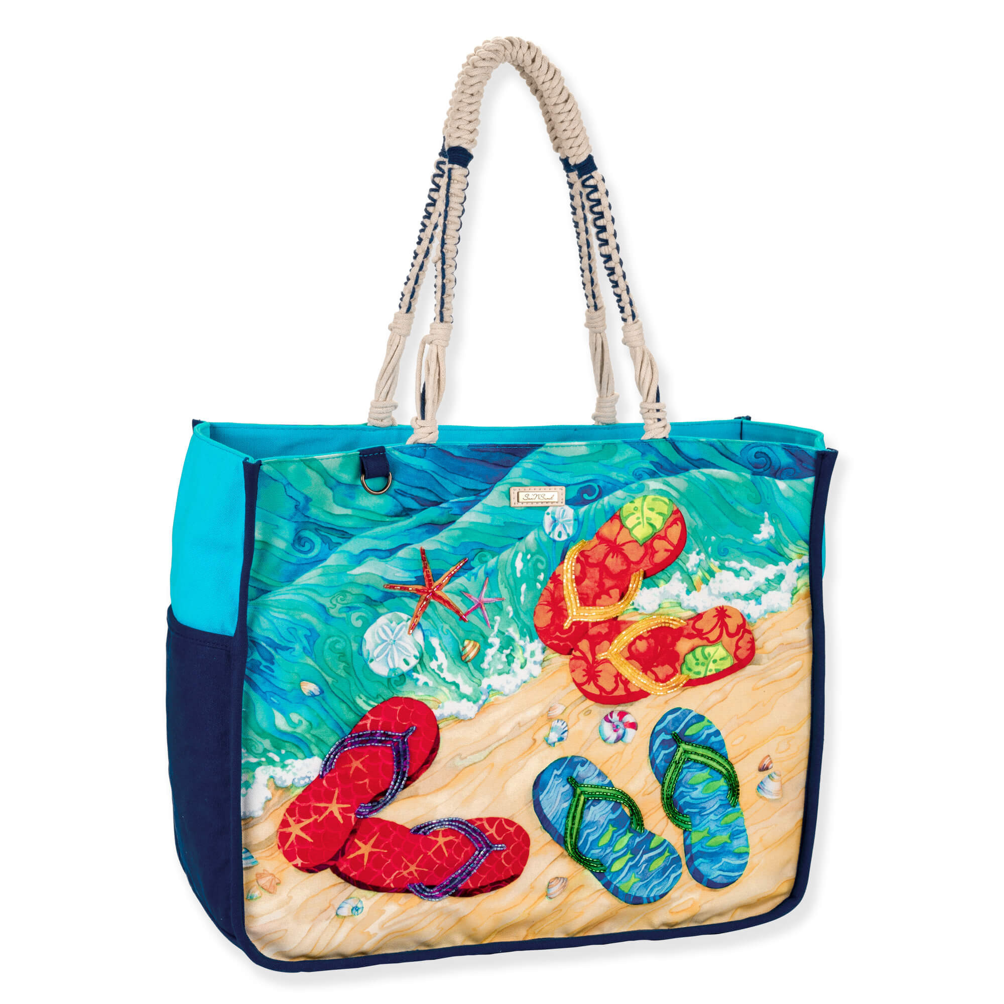 Three-quarter view of a rectangular canvas tote featuring colorful flip-flop beach graphics, braided rope handles, and silver metal hardware.