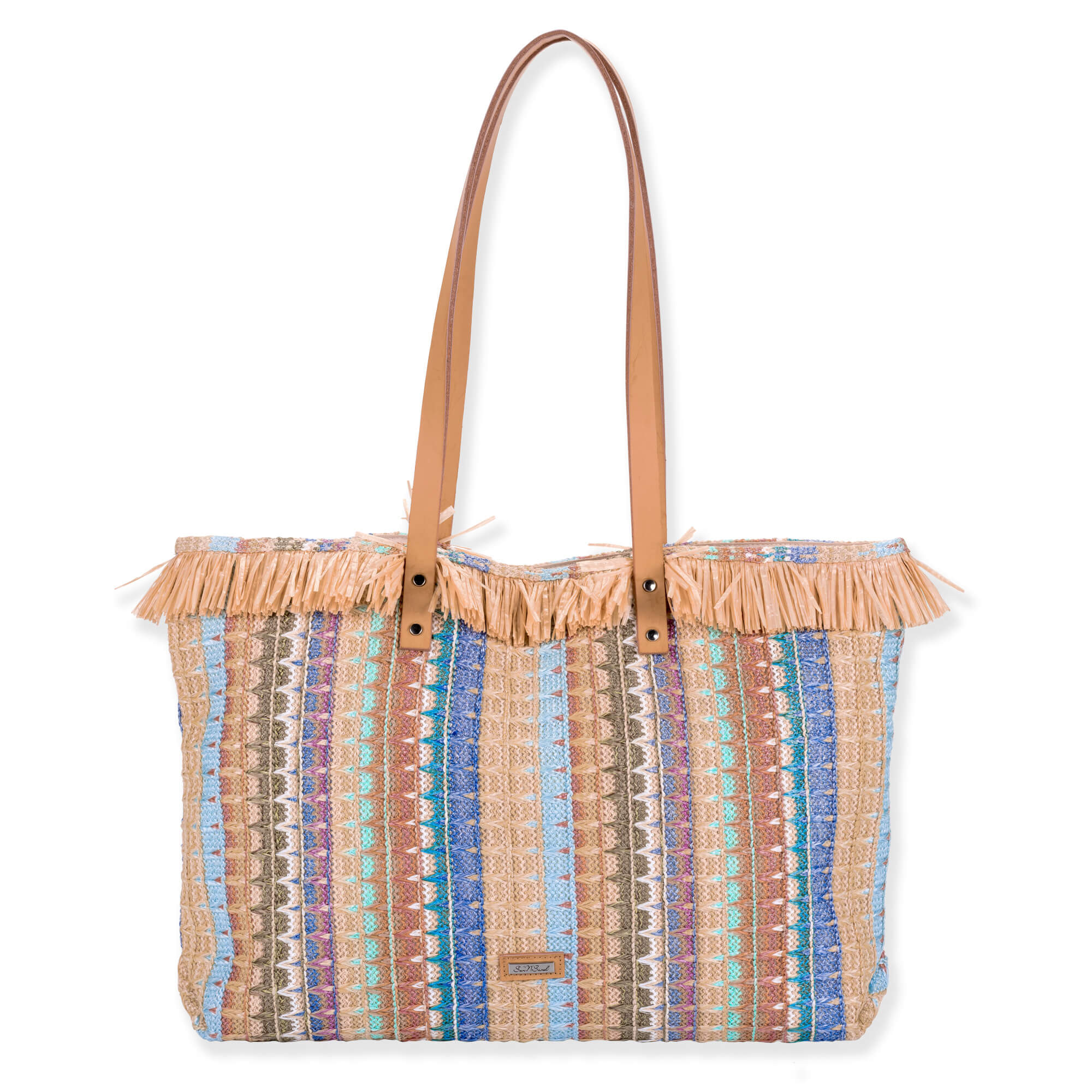 Front view of a rectangular woven tote featuring multi-colored vertical stripes, raffia fringe trim, tan leather handles, and metal rivets.