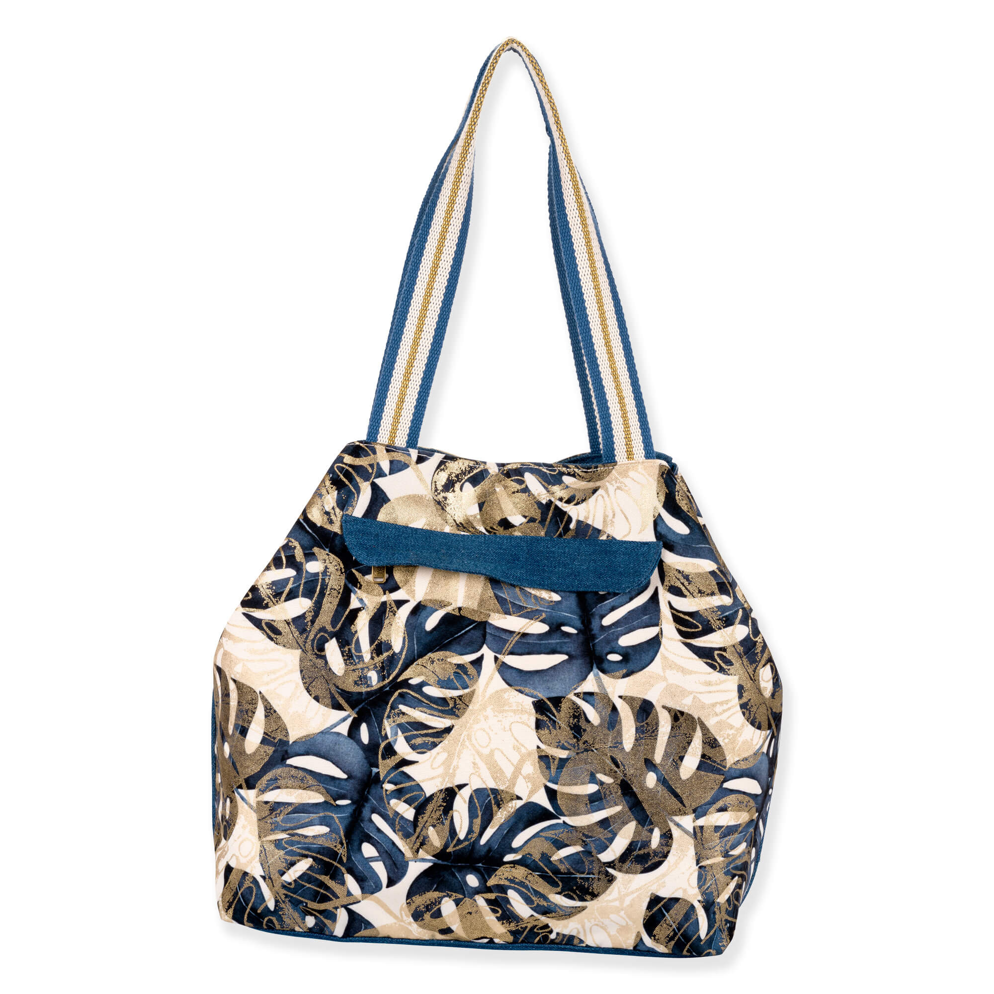 Back view of a slouchy canvas tote bag featuring a navy and gold monstera leaf print with striped shoulder straps.