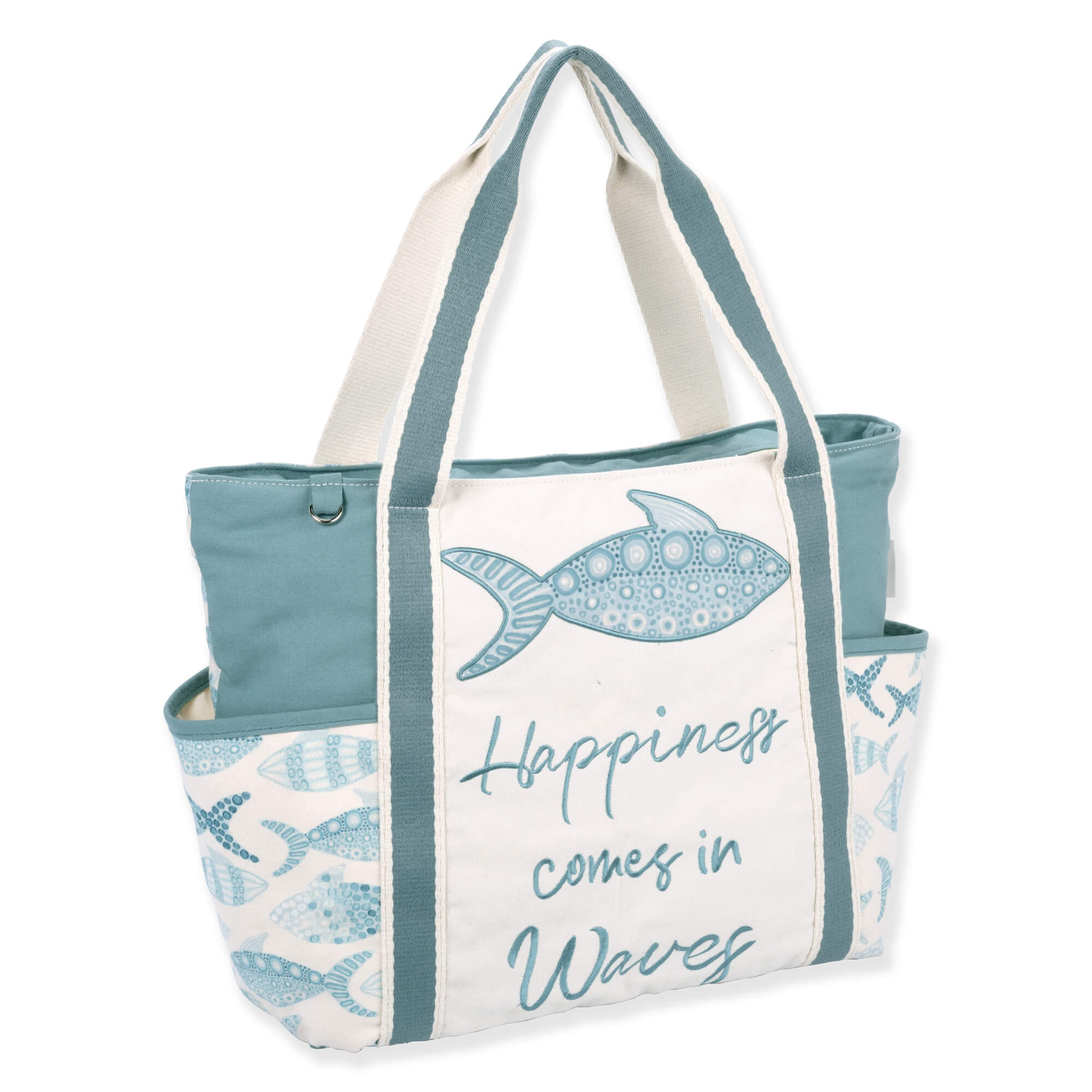 Three-quarter view of cream Sun 'N' Sand Pam Vale shoulder tote with teal fish print, canvas texture, and "Happiness" script.