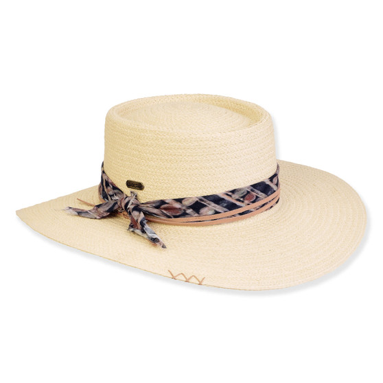 Three-quarter view of a cream woven boater hat featuring a patterned navy scarf band, metallic plaque, and side cross-stitch detailing.