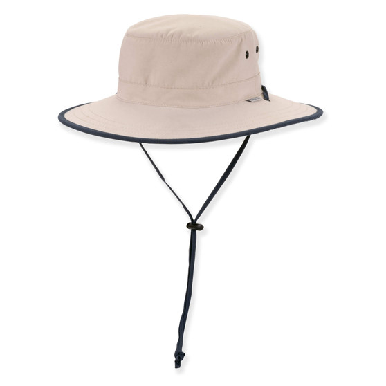 Three-quarter view of a cream performance bucket hat featuring a flat crown, navy-trimmed brim, side ventilation eyelets, and adjustable chin-strap.