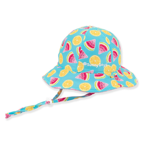 Three-quarter view of a bright blue sun hat with an all-over watermelon and lemon print, featuring a wide brim.