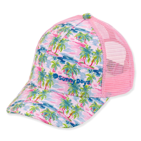 Three-quarter view of a pink trucker hat featuring green palm trees on a sunset-print crown and pink mesh back.
