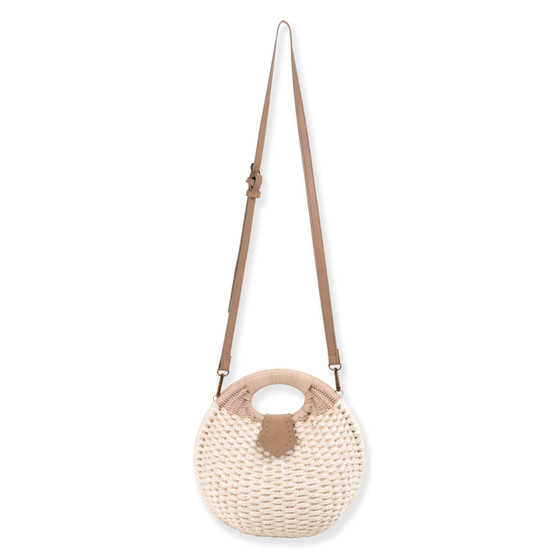 Front view of a circular woven straw bag featuring tan leather-wrapped handles, an adjustable crossbody strap, and antiqued gold-tone hardware