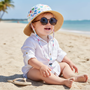 Lifestyle portrait of a children’s sun hat, featuring a playful multicolor heart pattern, a soft, wide brim, and a classic rounded crown designed for shaded beach comfort.