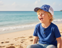 Lifestyle portrait of a children’s baseball cap, featuring a clean blue and white color-blocked pattern, a classic curved brim, and a structured crown designed for sun-safe beach play.