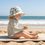Lifestyle portrait of a children’s sun hat, featuring a whimsical blue and purple sea turtle print, a soft wide-brimmed design, and a classic rounded crown for shaded beach play