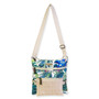 Tropical print crossbody bag with palm leaf fabric, woven straw lower pocket, flap closure, adjustable beige shoulder strap, front view shown