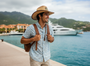 Lifestyle three-quarter view of the Sun N Sand HTT1278 men's western straw hat in Natural, featuring a patriotic flag patch on the crown and a contrasting bound brim with a leather chin strap for adventurous style and secure sun protection during travel.