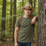 Lifestyle front view of the Sun N Sand HTT1259 men's western straw hat in Natural, featuring a decorative faux-leather band with a metal buckle and upturned side brims with a cattleman crown for rugged outdoor style and reliable sun protection while hiking.