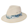 Three-quarter view of a cream straw fedora featuring a blue floral print band, side metal grommets, and oval logo hardware.