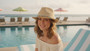 Lifestyle portrait of the Sun N Sand HH3513 Women’s Fedora Hat in natural-toned woven straw, featuring a turquoise-beaded hatband and a structured crown with a narrow brim for an adjustable fit and UPF 50+ sun protection.