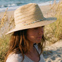 Lifestyle profile portrait of the Sun N Sand HH3606 Women’s Safari Hat in a natural woven straw, featuring a decorative beaded hatband with turquoise and white accents and a structured flat brim with a pinched crown for an adjustable fit.
